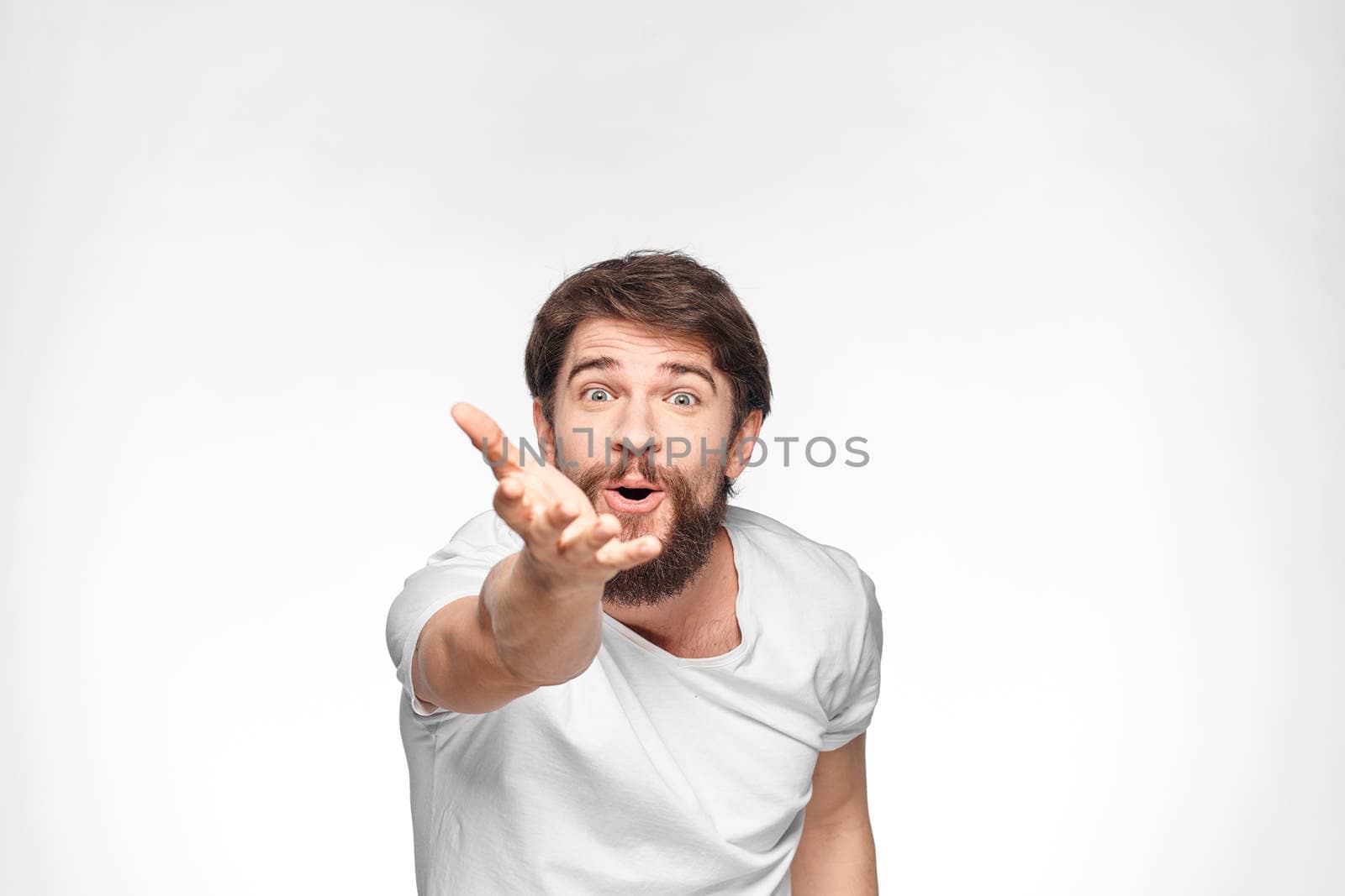 cheerful emotional bearded man gesturing with his hands close-up light background by SHOTPRIME