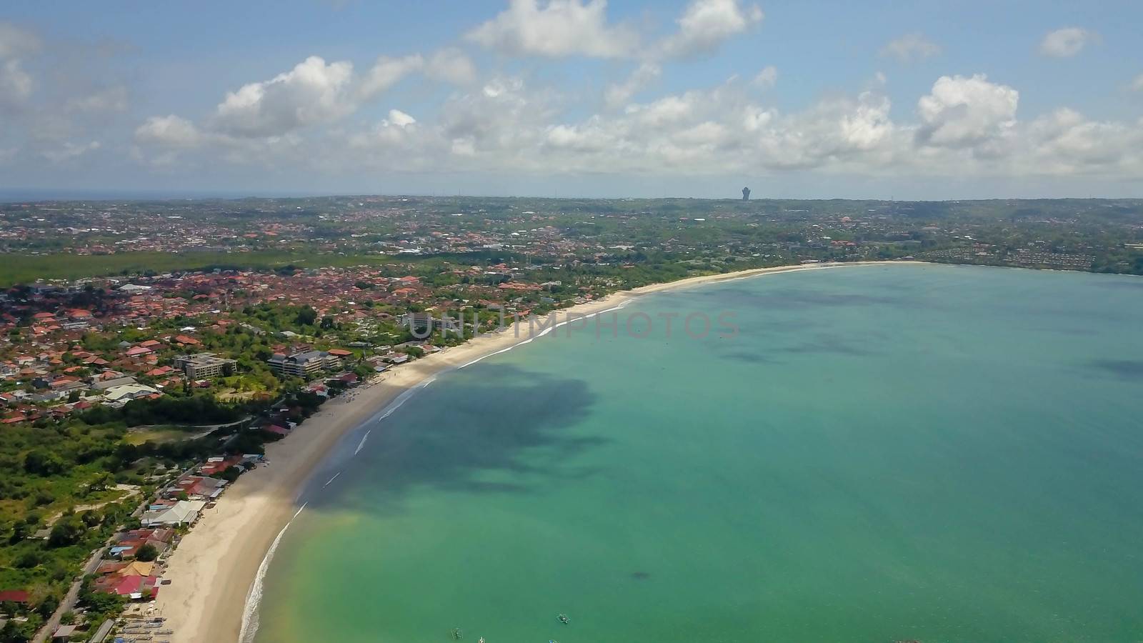 Aerial drone view of Holiday In Sanur Beach, Bali, Indonesia with ocean, boats, beach, villas, and people