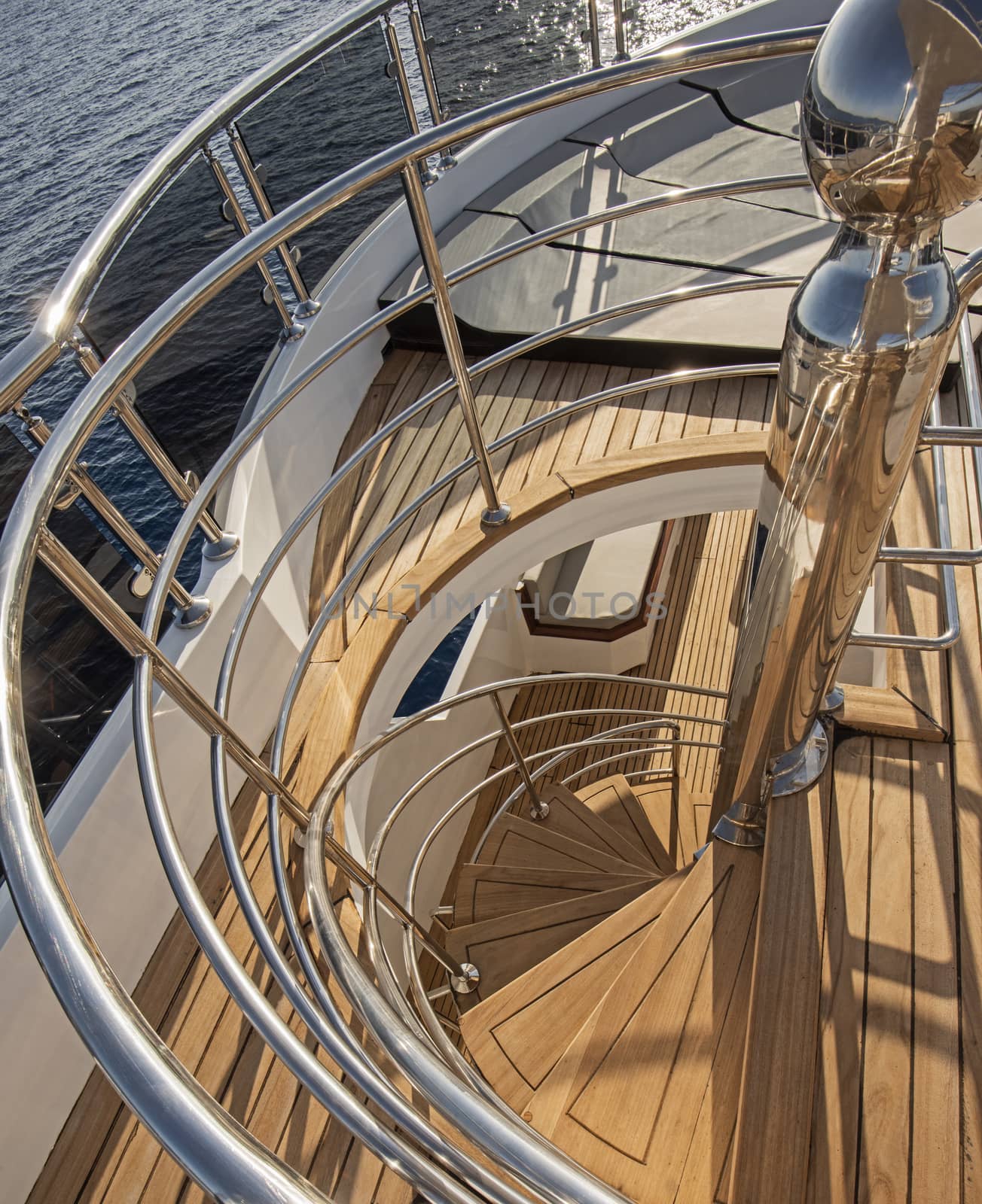 Abstract view of wooden curved spiral staircase on sundeck area of large luxury motor yacht