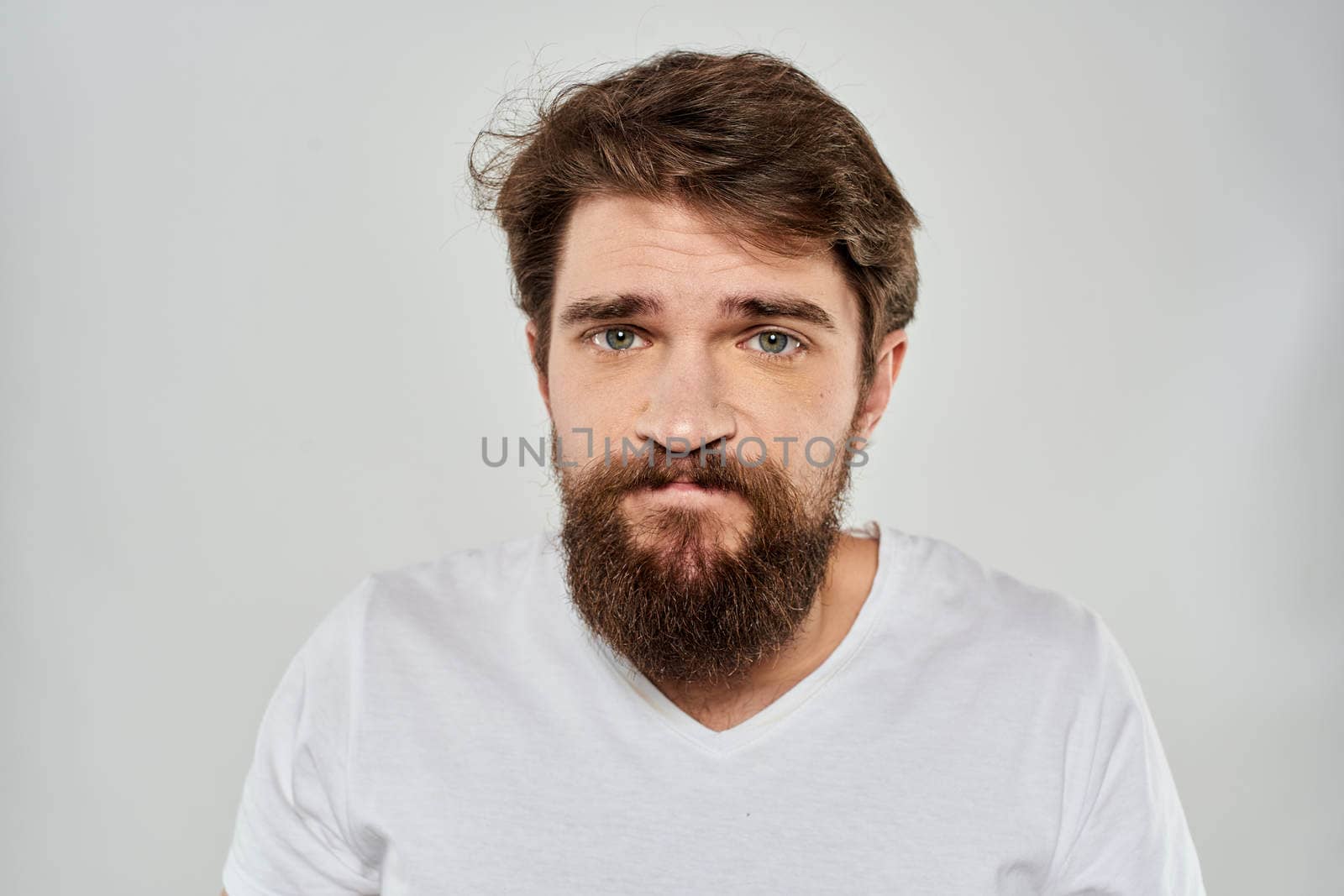 Bearded man gesturing with hand white cropped t-shirt studio lifestyle. High quality photo