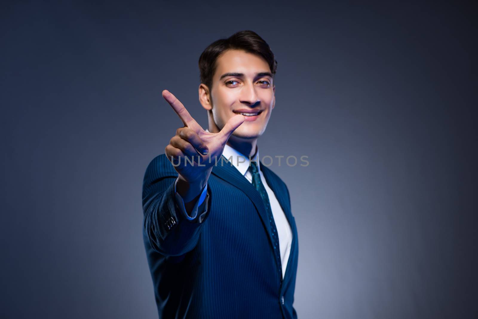 Businessman pressing virtual buttons on gray background
