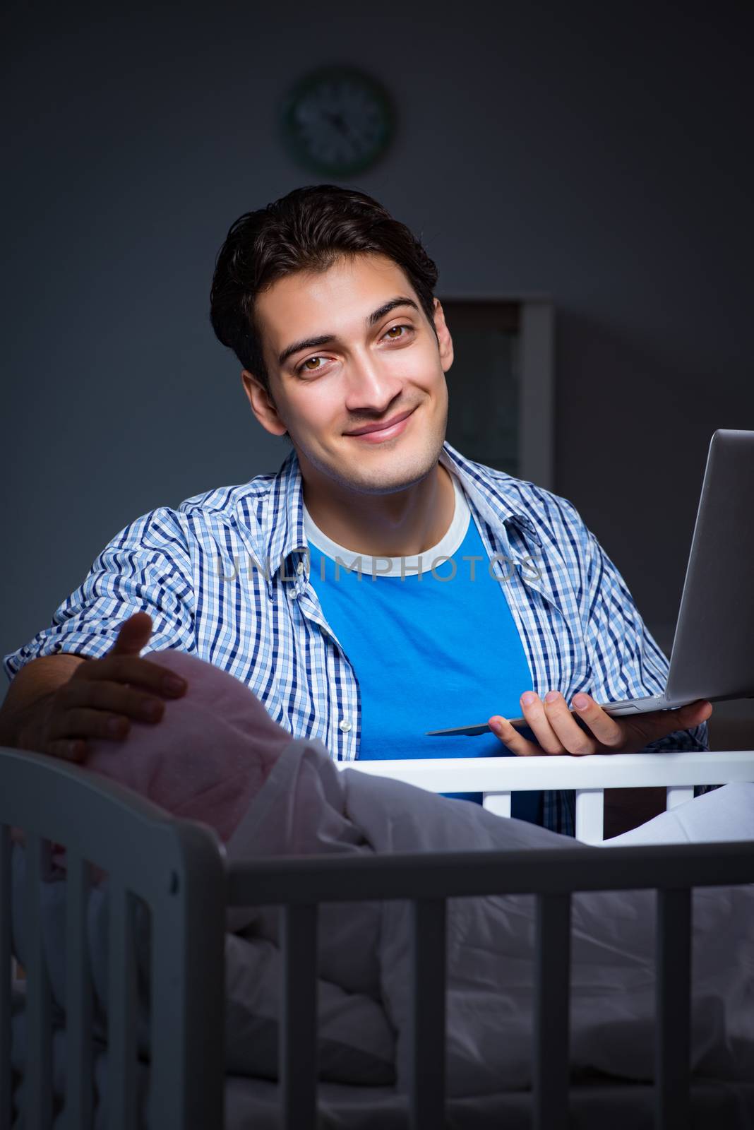 Young student doing homework and looking after newborn baby