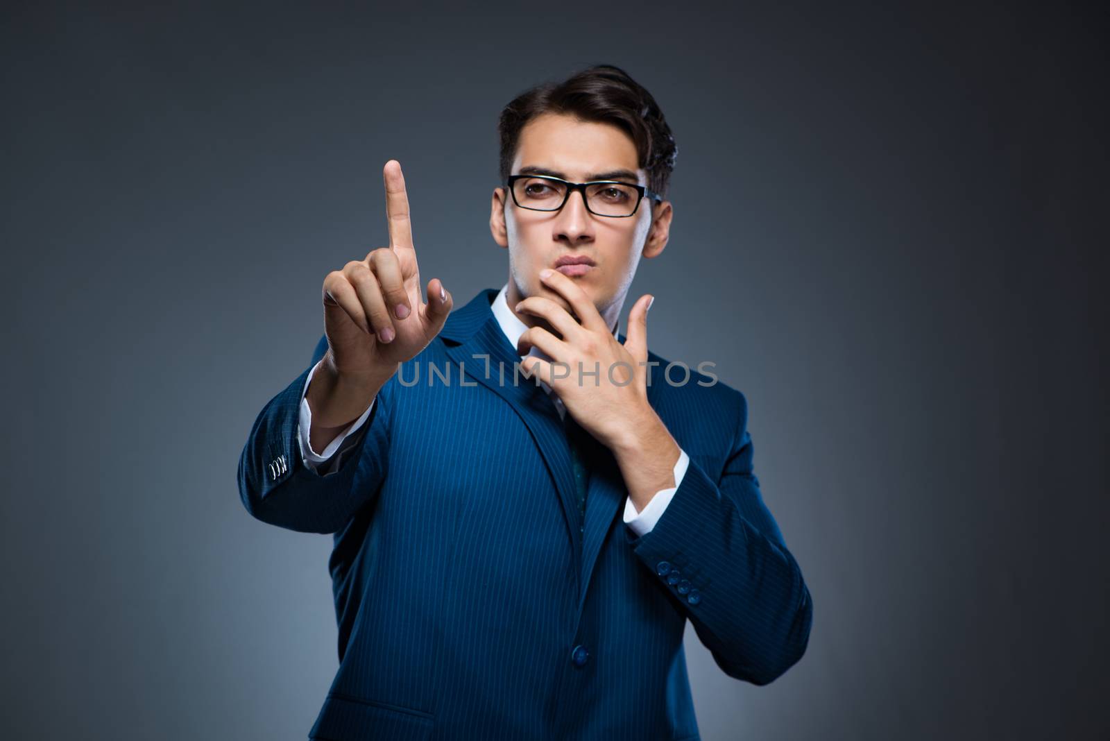 Businessman pressing virtual buttons on gray background