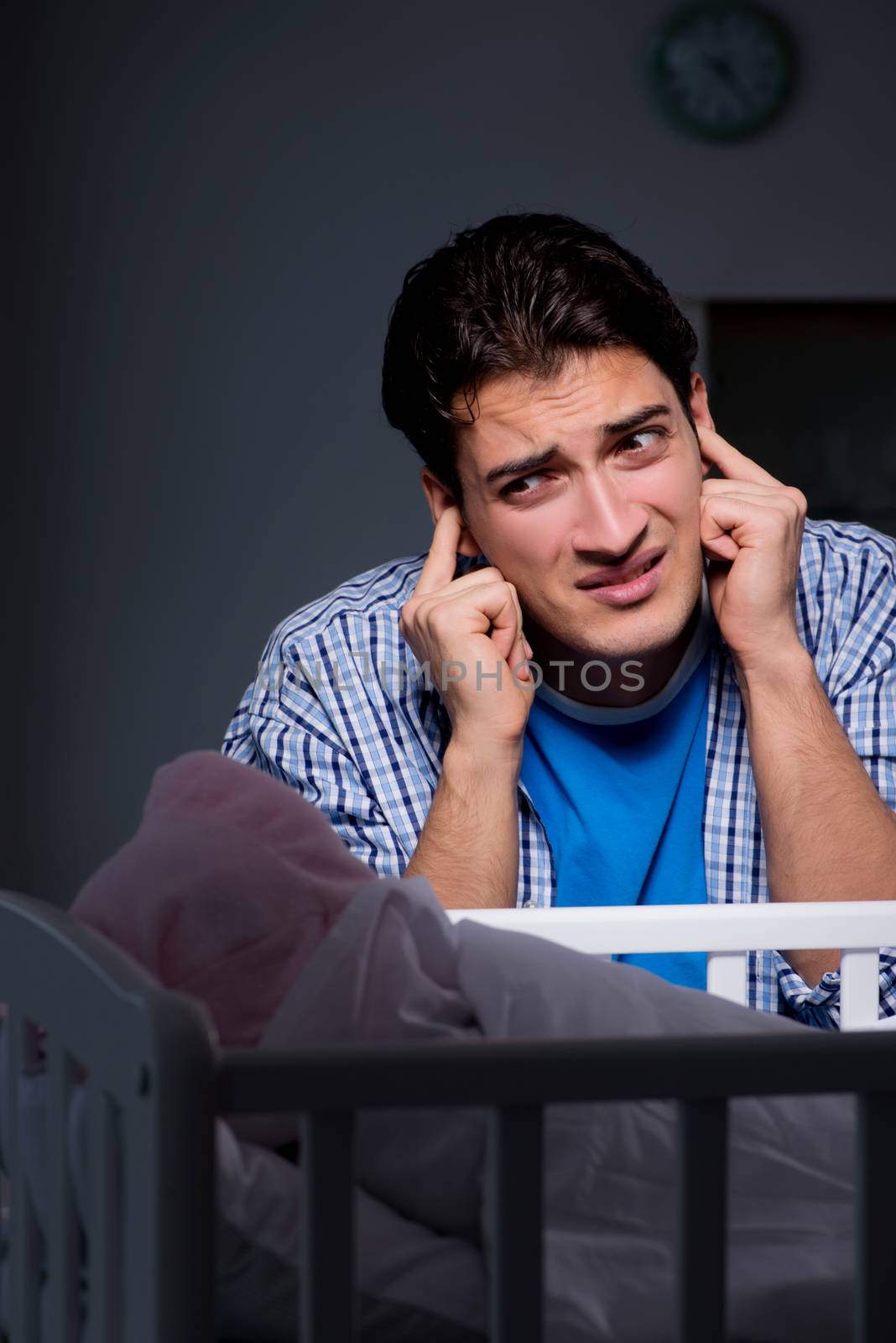 Young father under stress due to baby crying at night