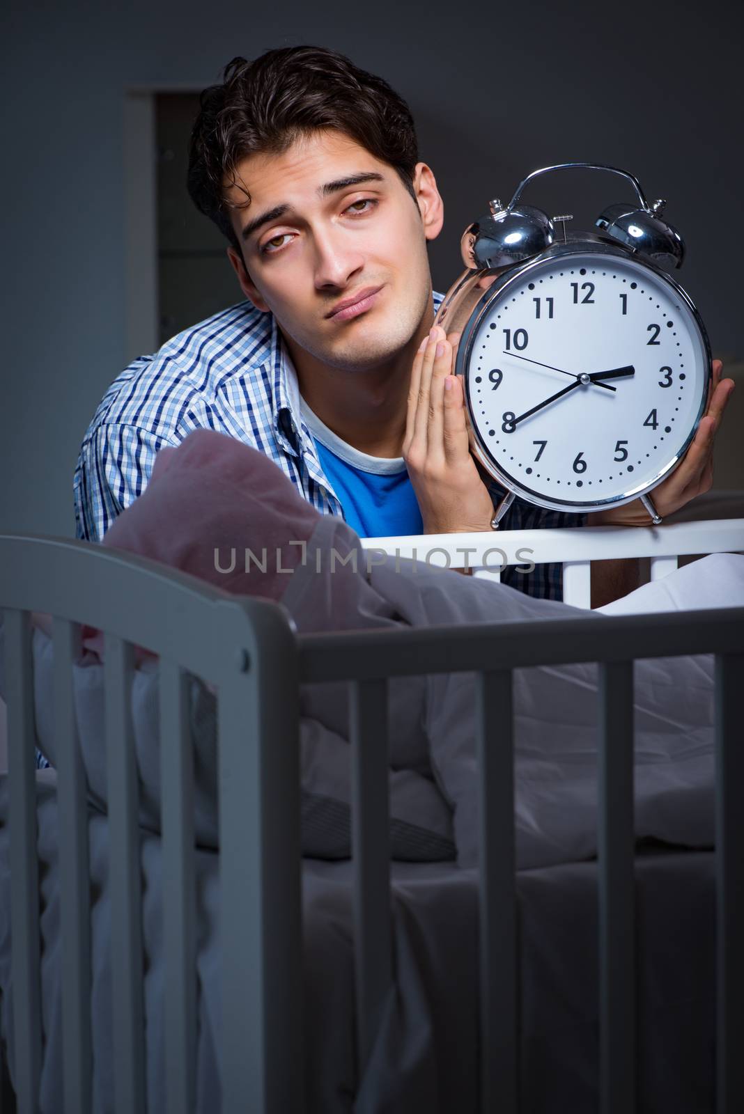 Young father dad sleeping while looking after newborn baby