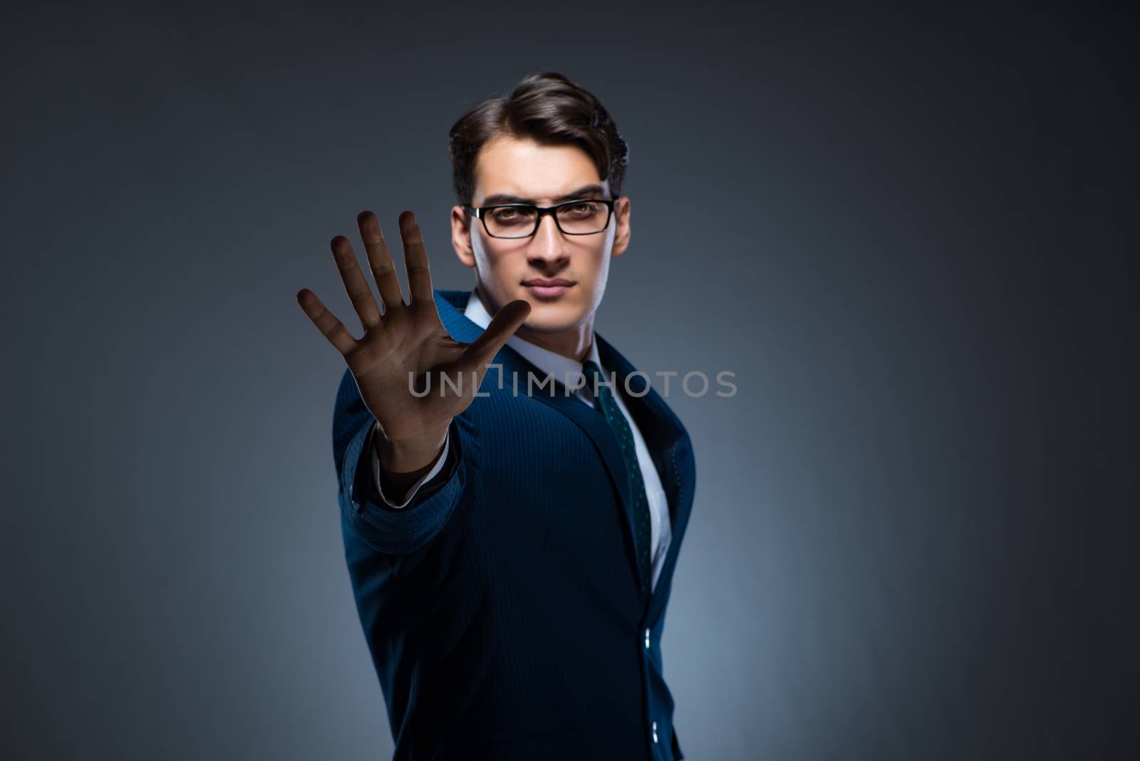 Businessman pressing virtual buttons on gray background