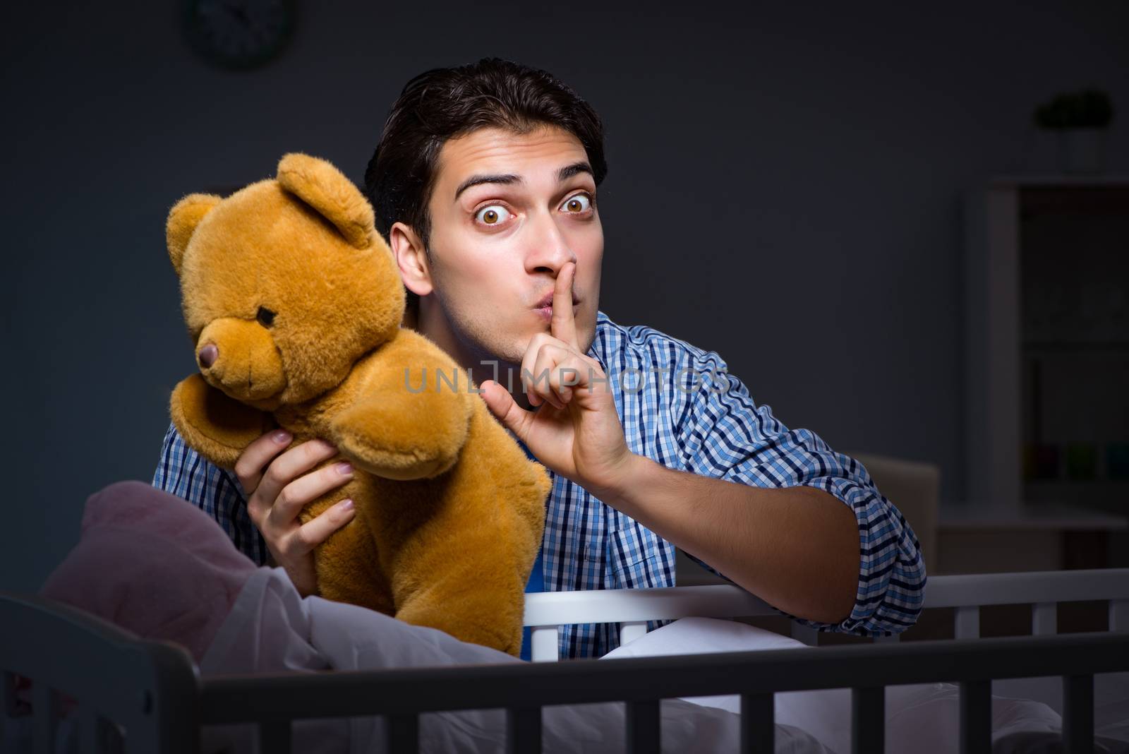 Happy dad looking after newborn baby at night