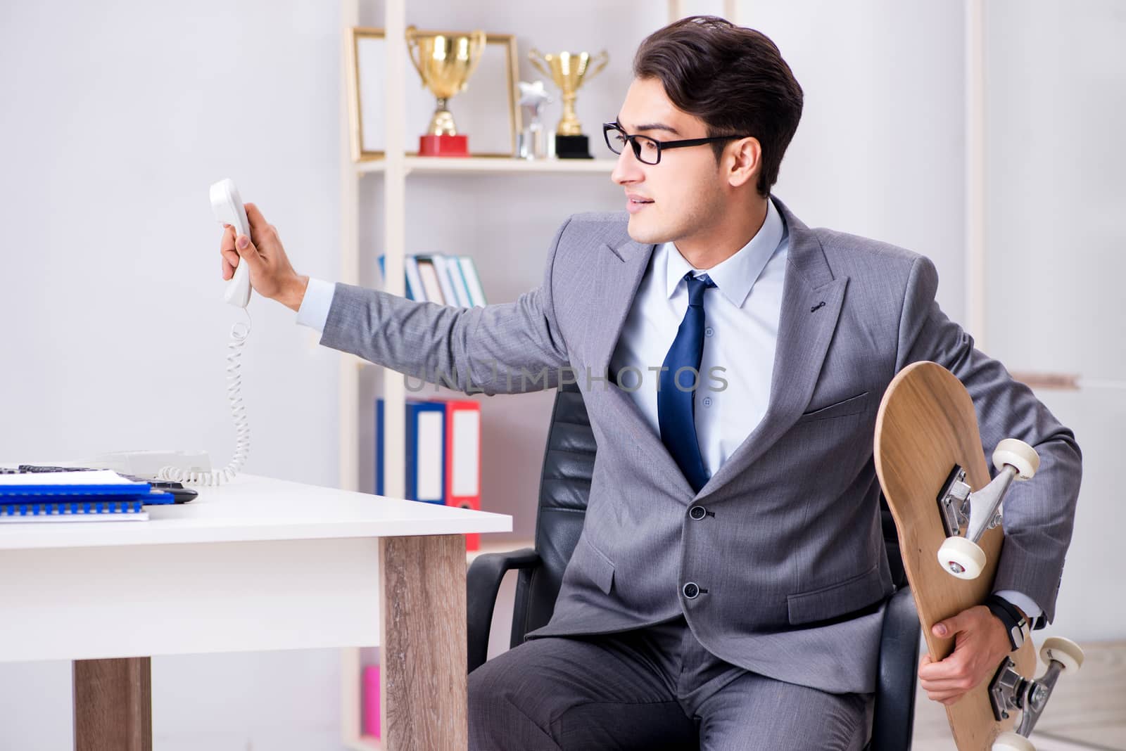 Young businessman riding skate in office during break