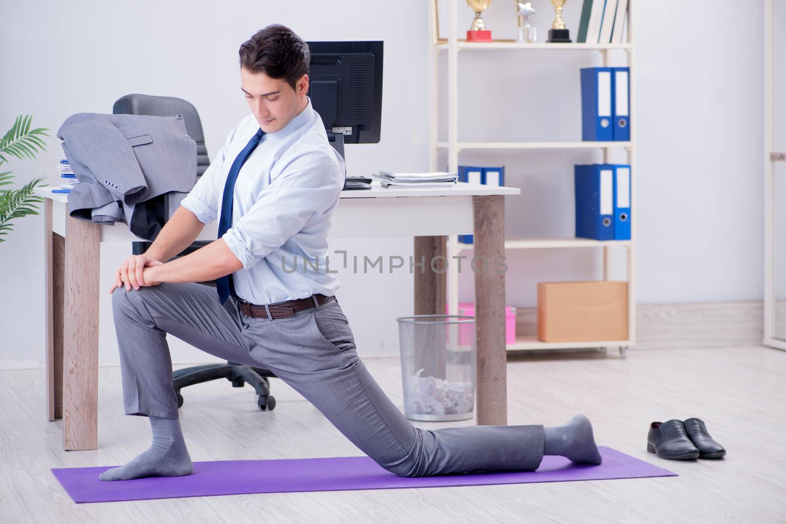 Businessman doing sports in office during break