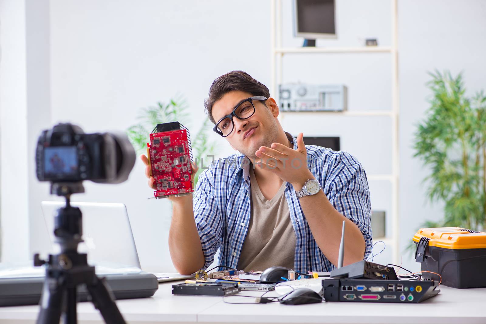 Vlogger recording computer repair on camera for vlog blog