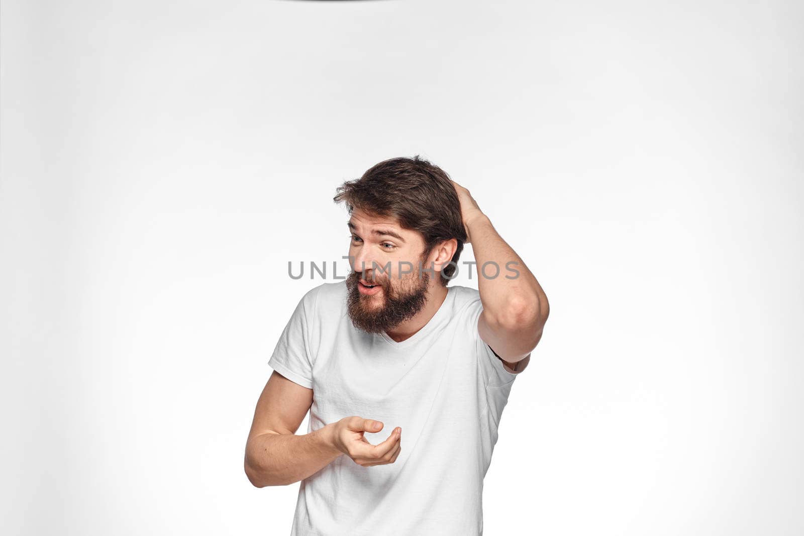 cheerful emotional bearded man gesturing with his hands close-up light background. High quality photo