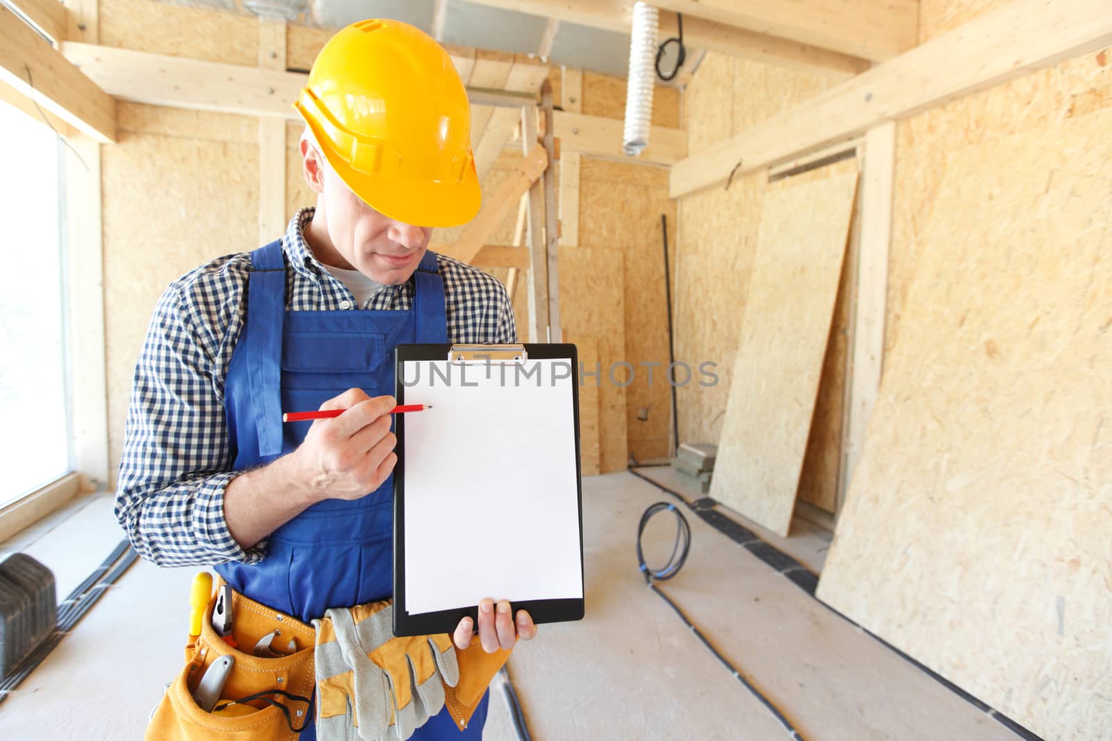 Worker showing document at construction site area, blank copy space for text