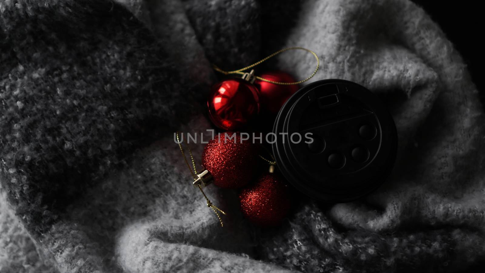 Coffee Cup with red Christmas balls on a grey background. Christmas composition. A festive concept for a coffee shop.