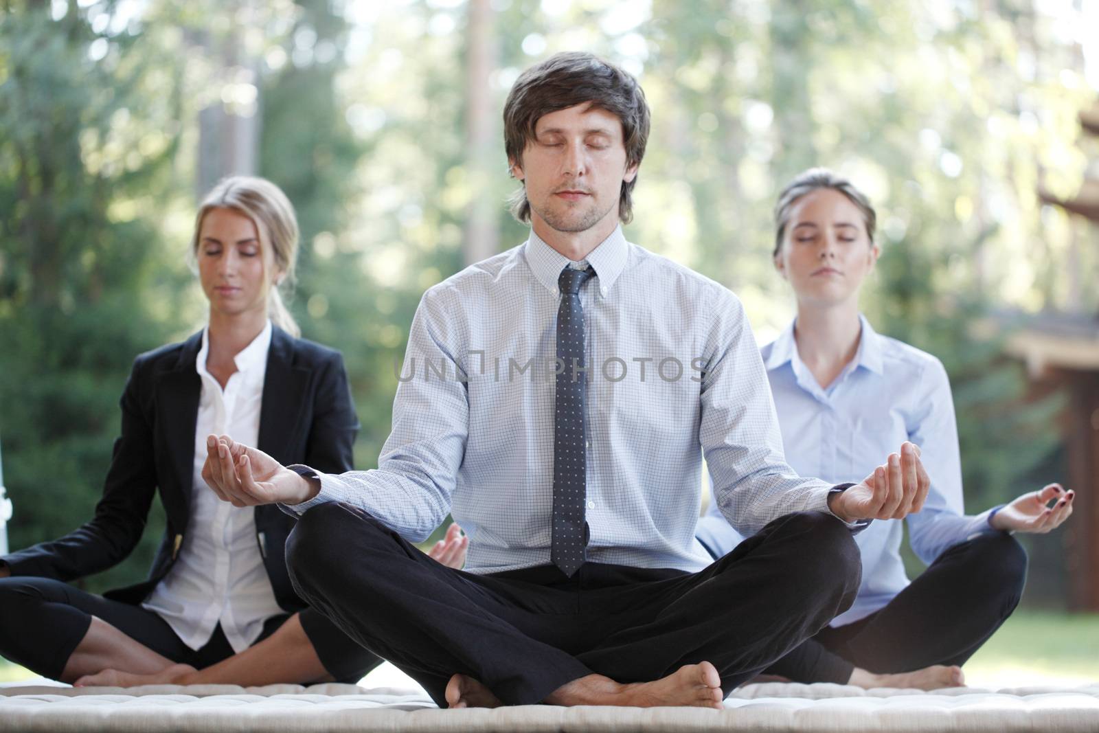 Business team practicing yoga by ALotOfPeople