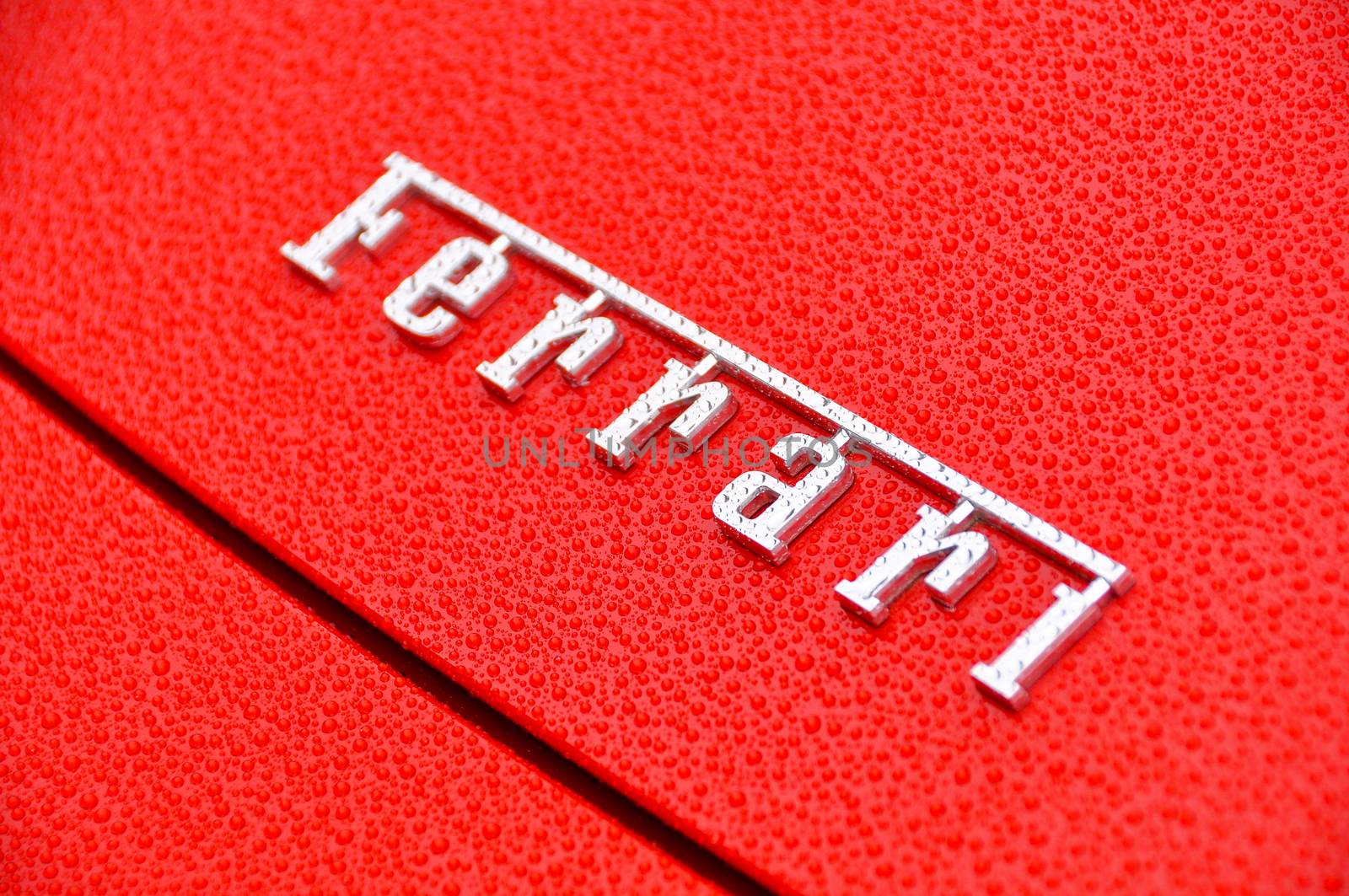 Ferrari sign on wet red bodywork by dutourdumonde