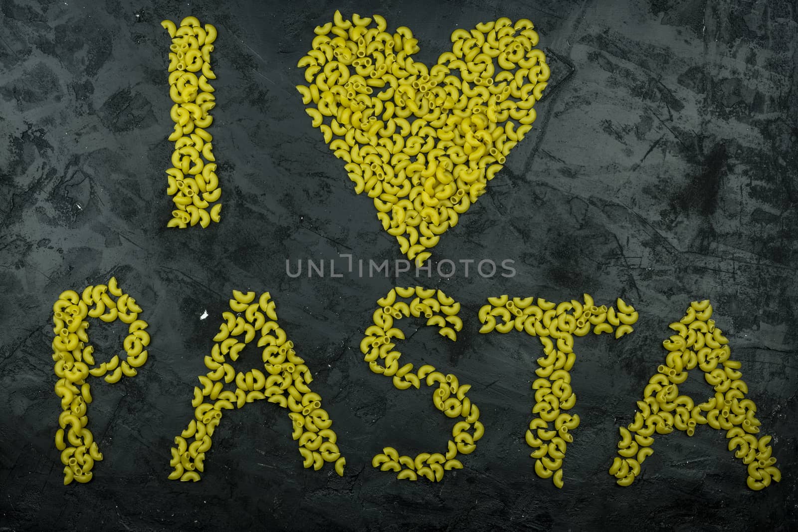 Pasta in the shape of a heart on a black background.
