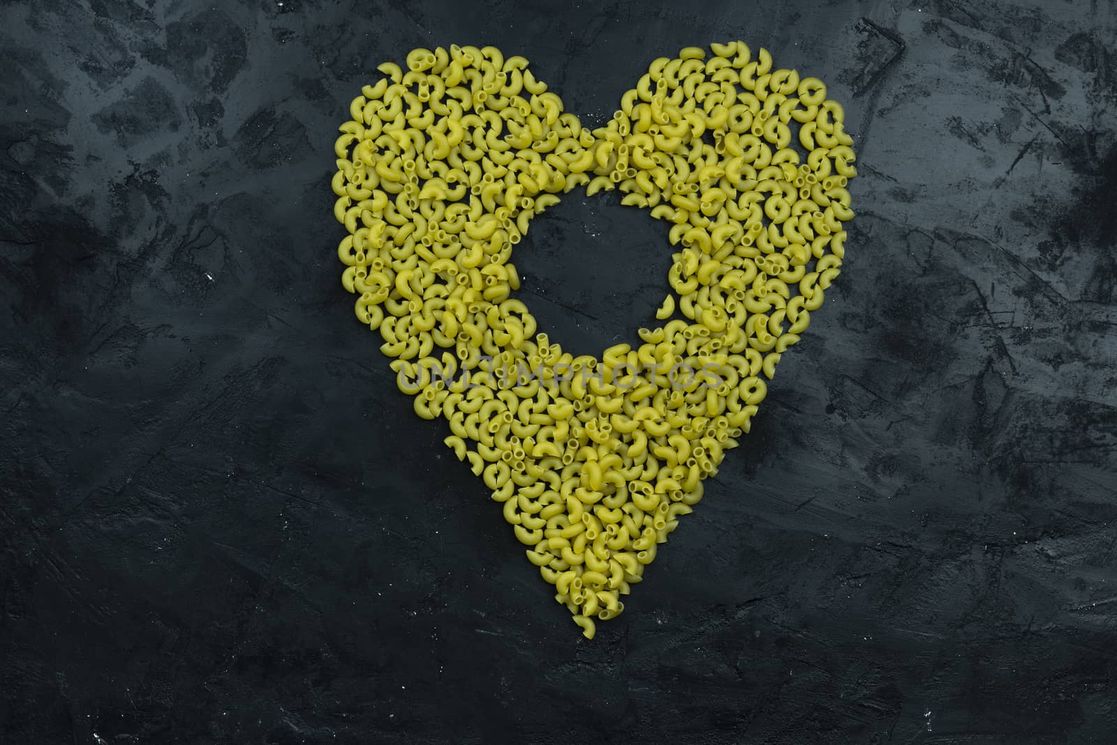 Pasta in the shape of a heart on a black background by sashokddt