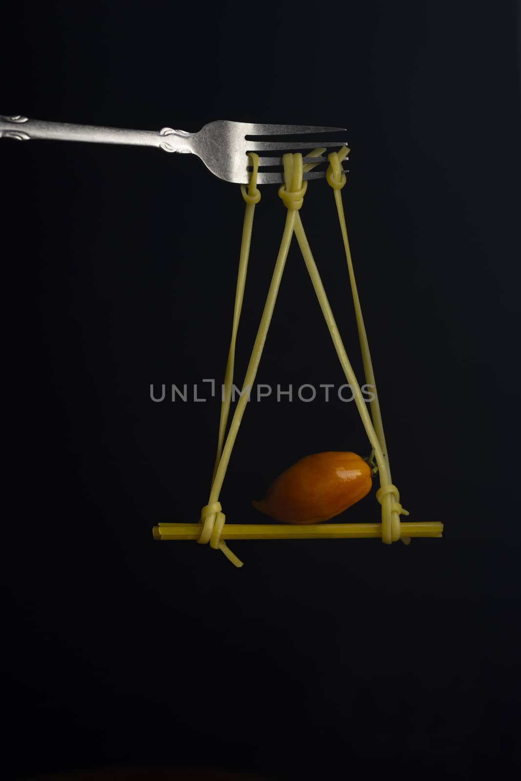 Spaghetti on a fork in front of black background. Swing from spaghetti.