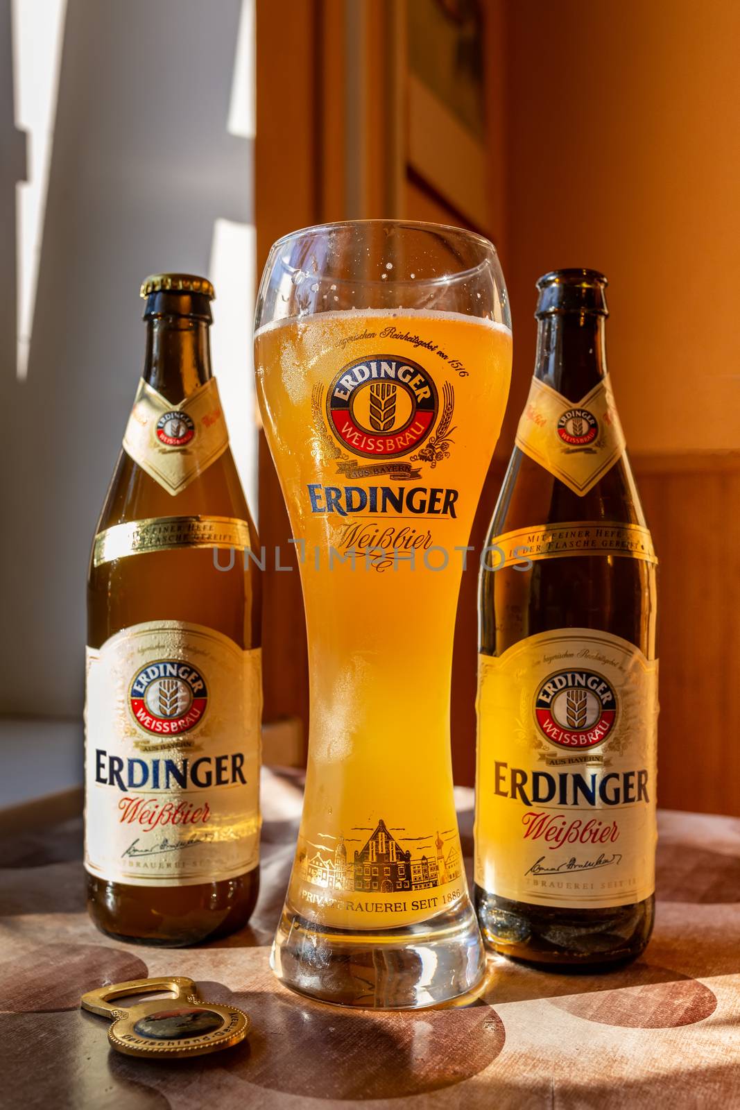Erdinger beer is poured in a branded beer glass and two bottles of beer on the side. Erdinger beer on the table. 04.07.2015 Kiev Ukraine