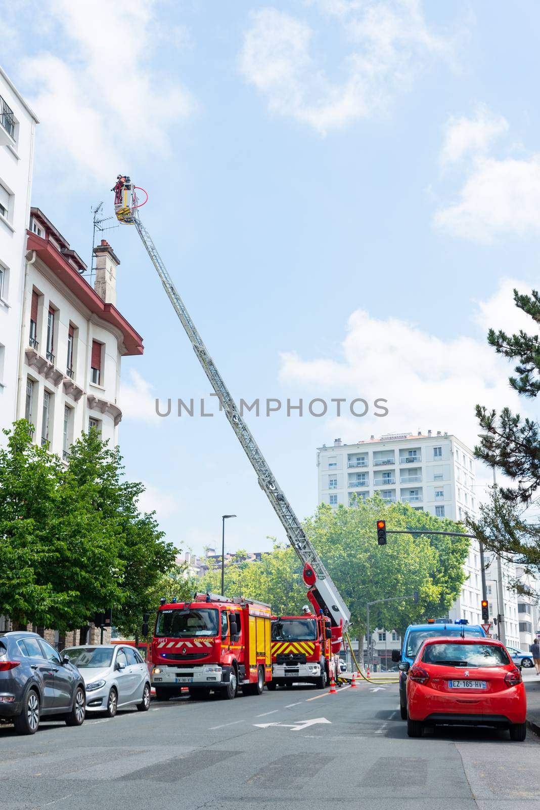 BAYONNE, FRANCE - 22 MAY, 2020: Firemen spray water to put out last floor apartment fire.