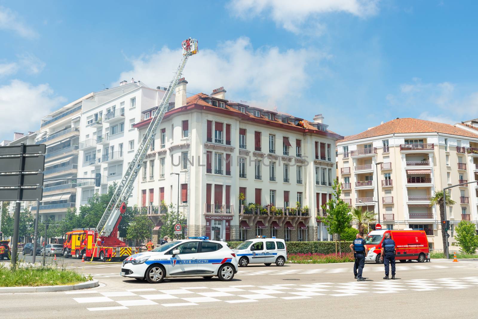 BAYONNE, FRANCE - 22 MAY, 2020: Firemen spray water to put out last floor apartment fire.