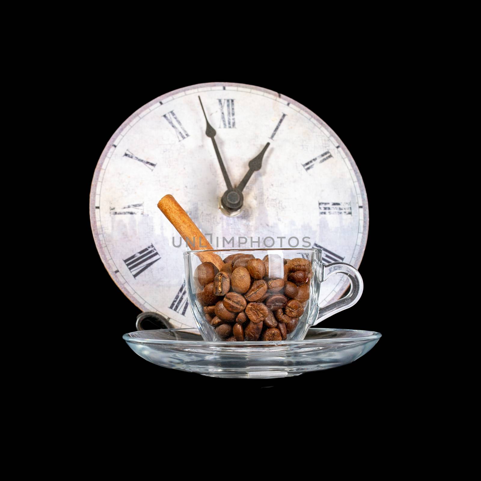 Coffee cup with grains isolated on a black background. Coffee beans and vanilla stick in a coffee cup on a saucer. Against the background of vintage watches.