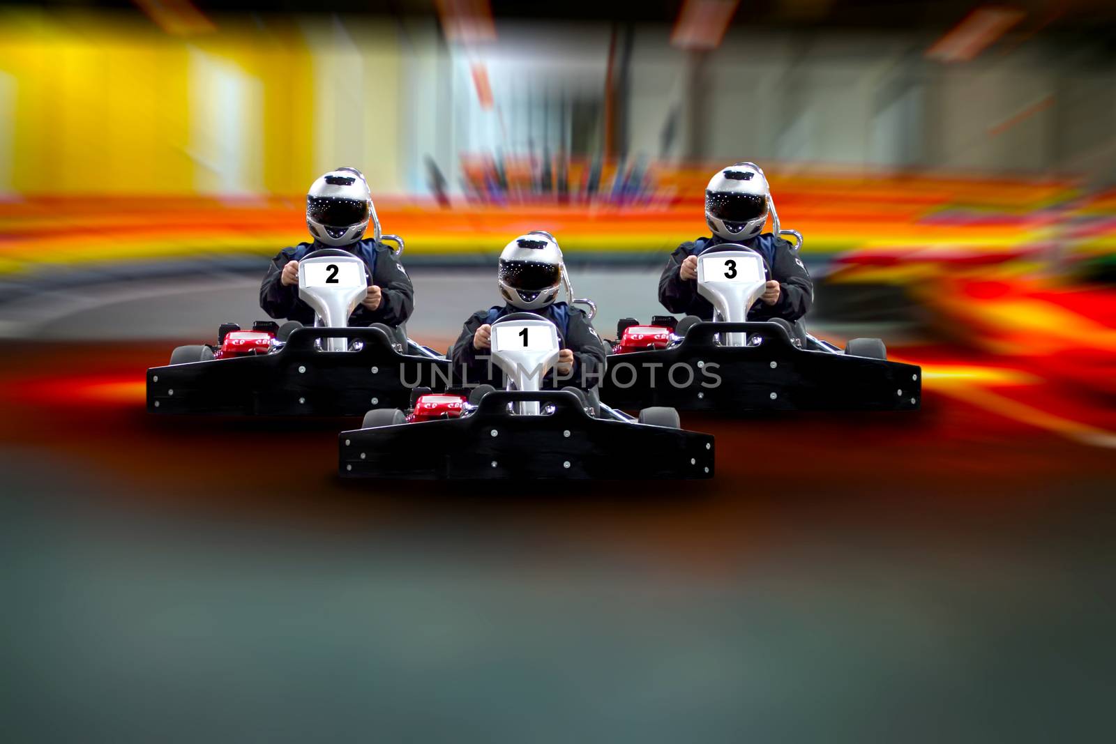 Three riders Go kart speed rive indoor race on the background of the track. Go kart indoor, cart racing fast, car where gokarting, we speed racing, racers banner Copy space.