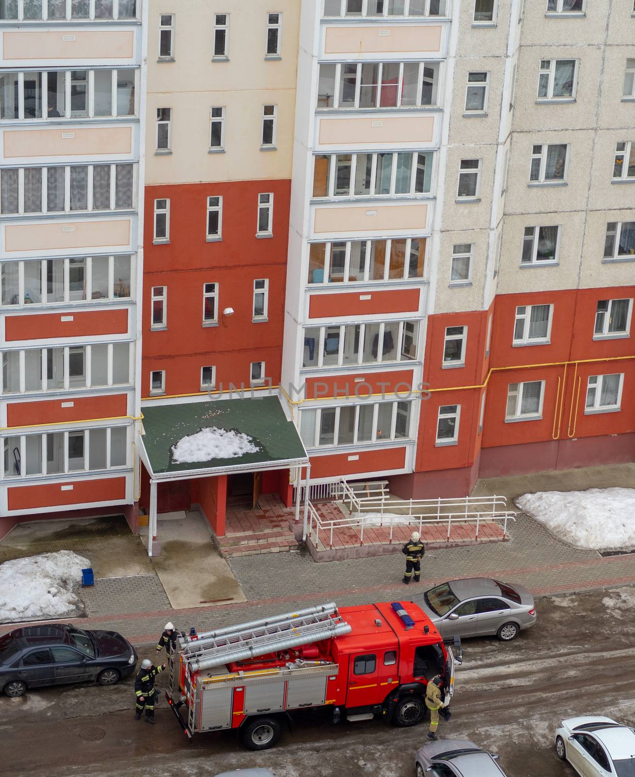 Fire engine in the courtyard of a multi-storey residential building in winter.