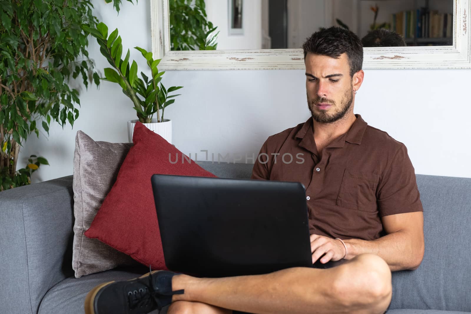 Handsome male businessman working on laptop and typing from home