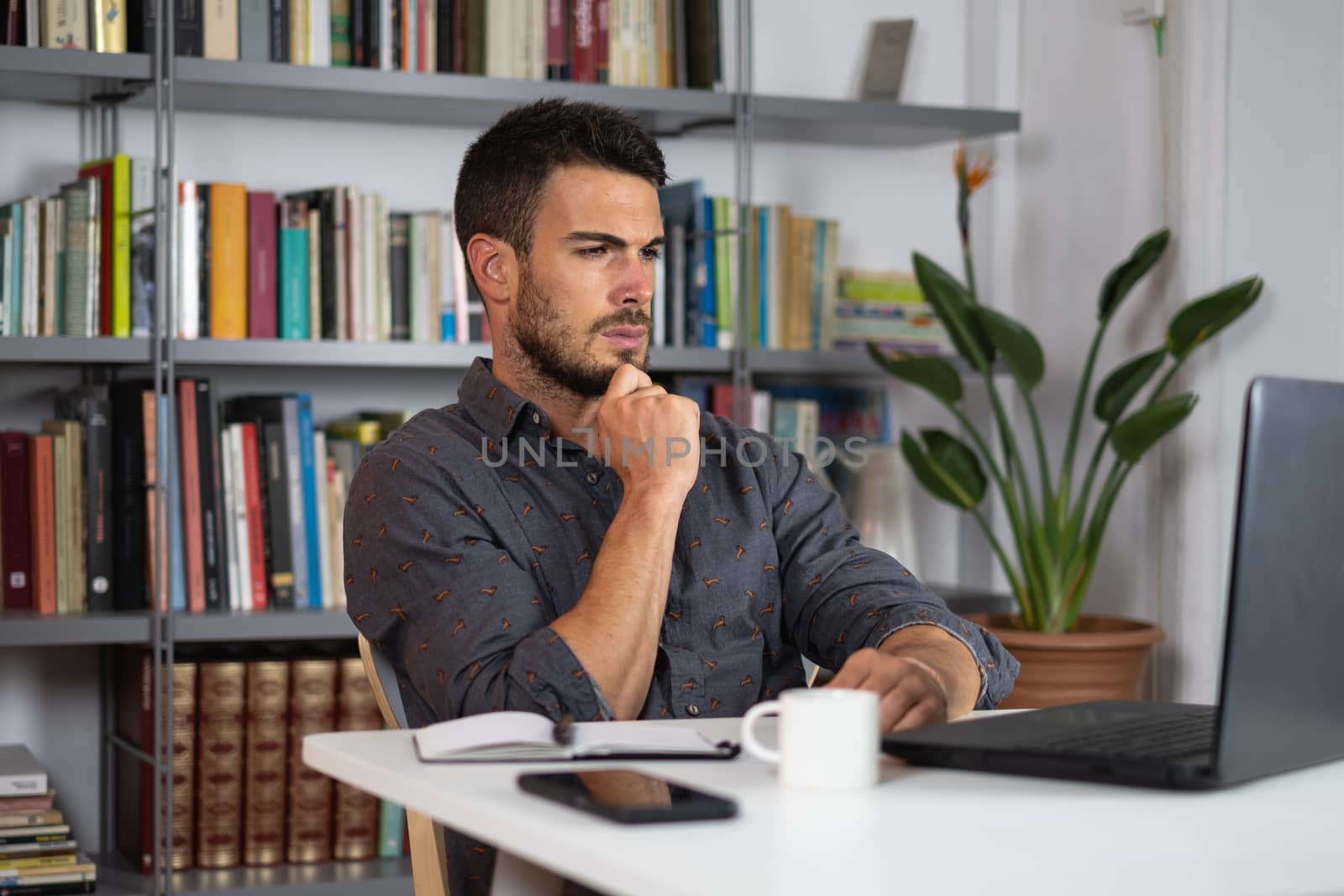 Handsome male working on laptop from home by Dumblinfilms