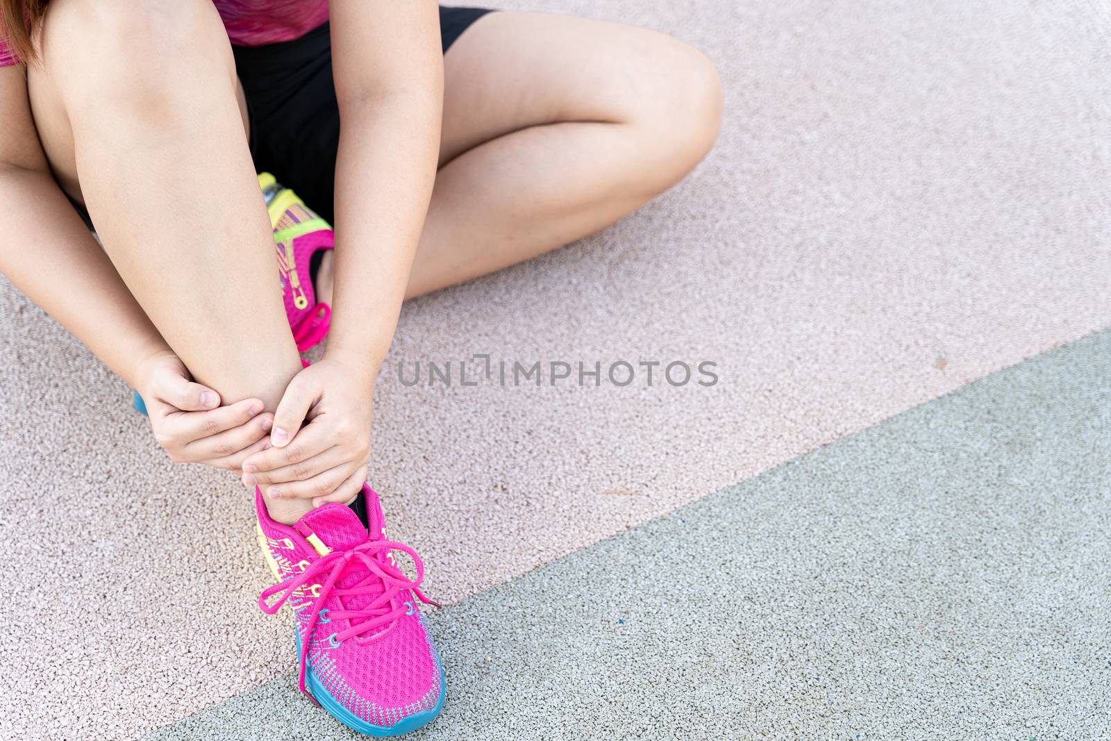 Female fatty runner athlete leg injury and pain. Hands grab painful leg while running in the park.