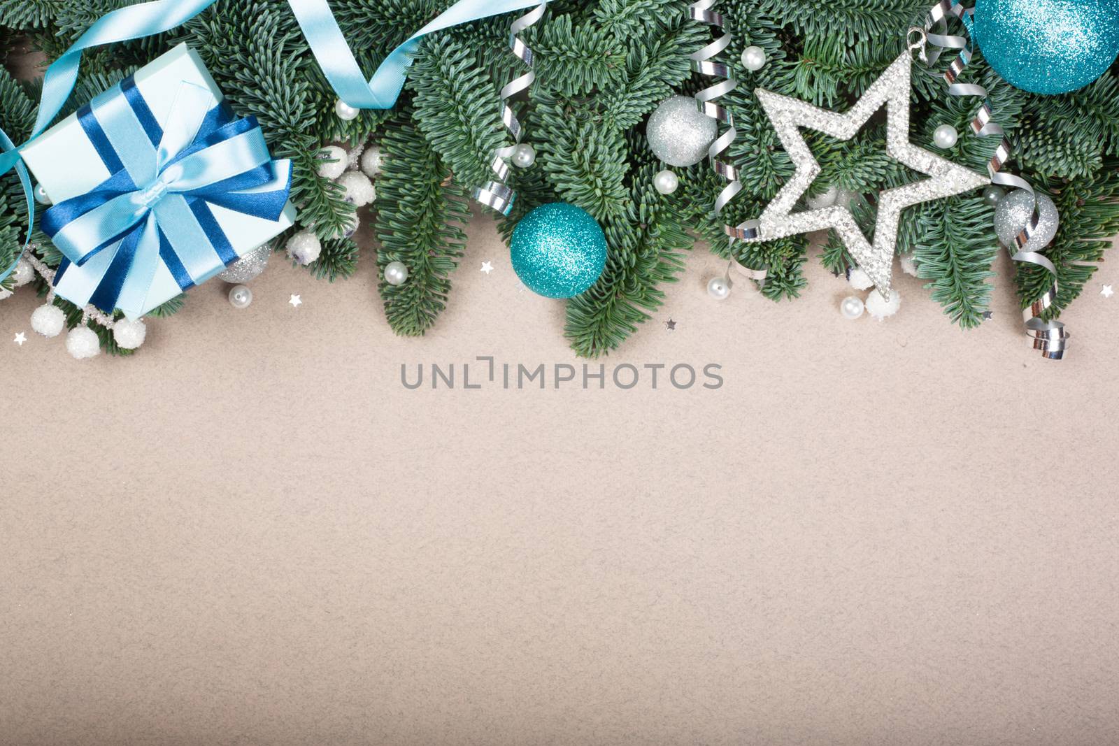 Christmas noble fir tree twigs gift and decorations on brown paper background with copy space for text