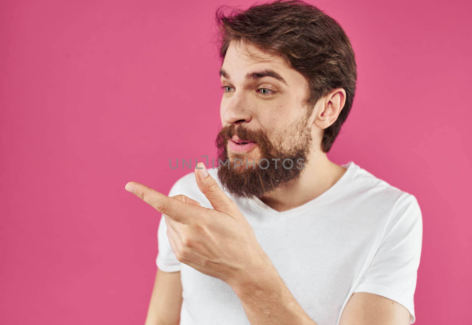 Cute guy with beard on pink background close-up portrait cropped view. High quality photo