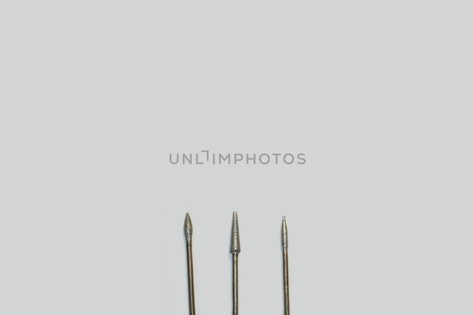 Set of three milling cutters. Manicure tool. Used manicurist professional tools on a white background with free space for text.