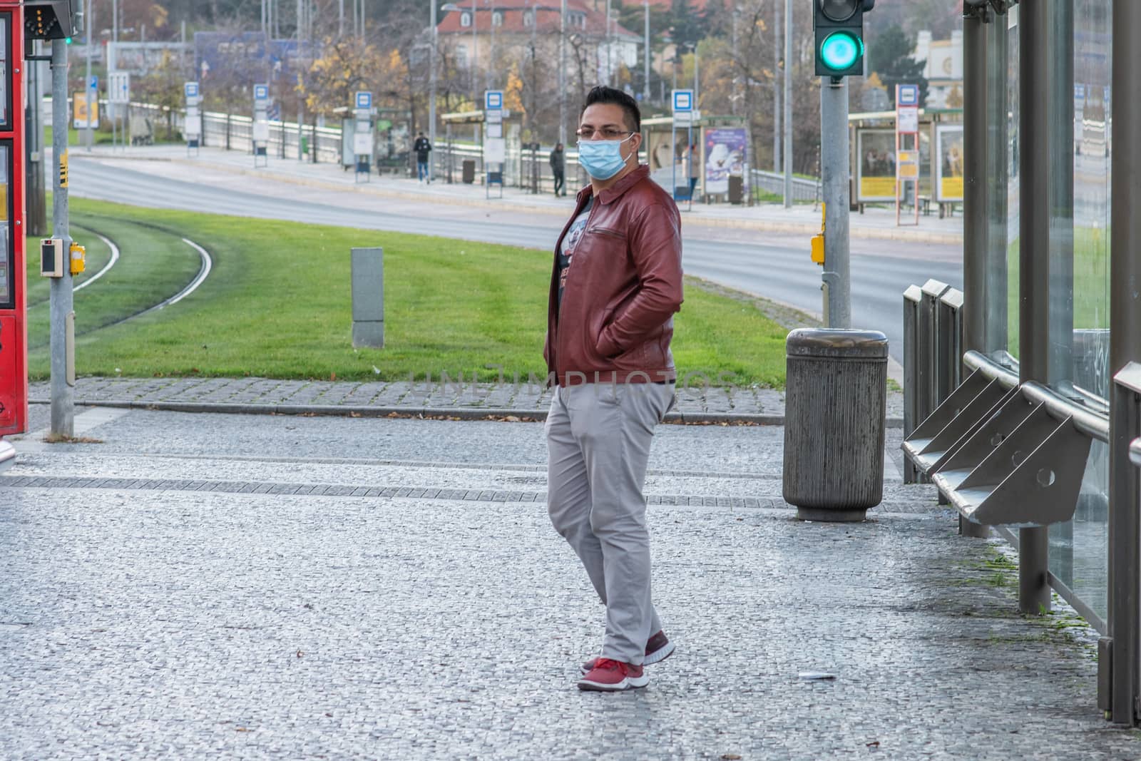 11/16/2020. Prague. Czech Republic. A man wearing a mask is waiting for a tram at Hradcanska tram stop during quarantine. by gonzalobell