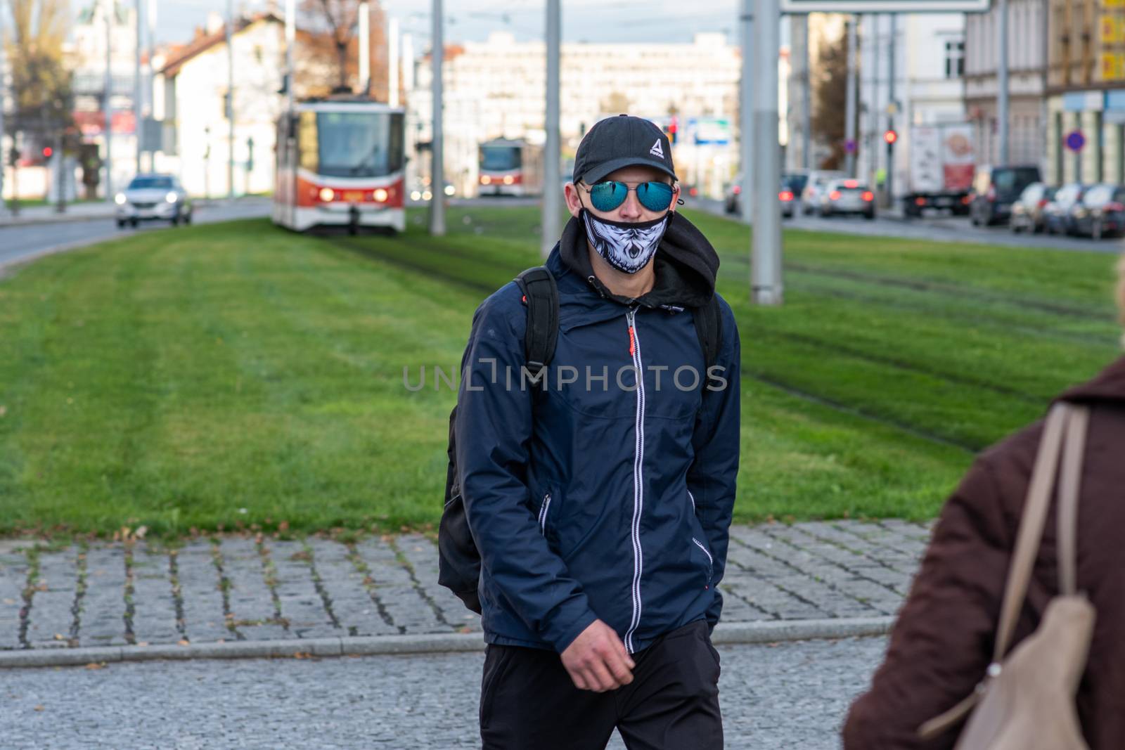 11/16/2020. Prague. Czech Republic. A man wearing a mask is crossing the railways at Hradcanska tram stop during quarantine. This is a lockdown period in the Czech Republic due to the increase of COVID-19 infectious in the country. Hradcanska tram stop it is in Prague 6