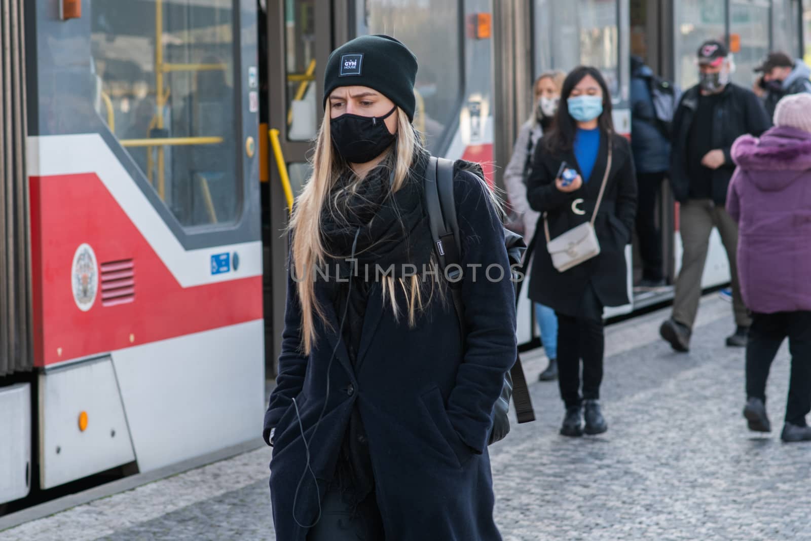 11/16/2020. Prague. Czech Republic. A woman wearing a mask is getting of the tram at Hradcanska tram stop during quarantine. This is a lockdown period in the Czech Republic due to the increase of COVID-19 infectious in the country. Hradcanska tram stop it is in Prague 6