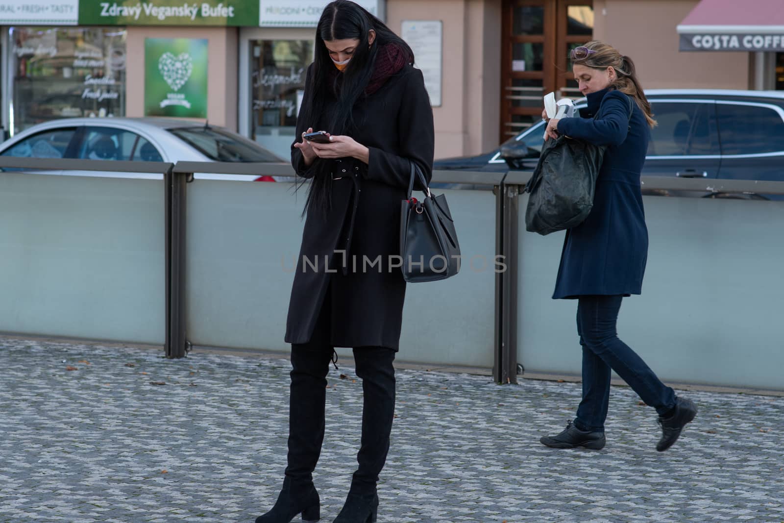 11/16/2020. Czech Republic. A woman wearing a mask is waiting for a tram at Hradcanska tram stop during quarantine. by gonzalobell