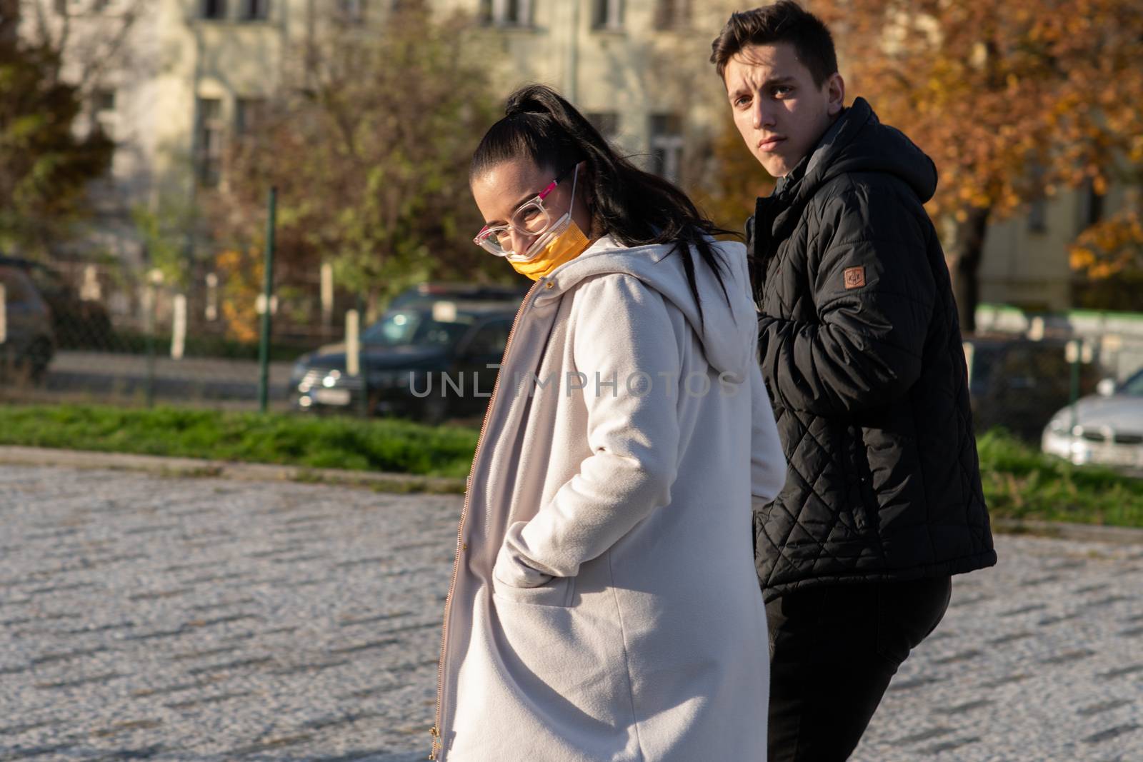 11/16/2020. Prague, Czech Republic. A couple is walking close to Hradcanska tram stop during quarantine (she is wearing a mask). This is a lockdown period in the Czech Republic due to the increase of COVID-19 infectious in the country. Hradcanska tram stop it is in Prague 6