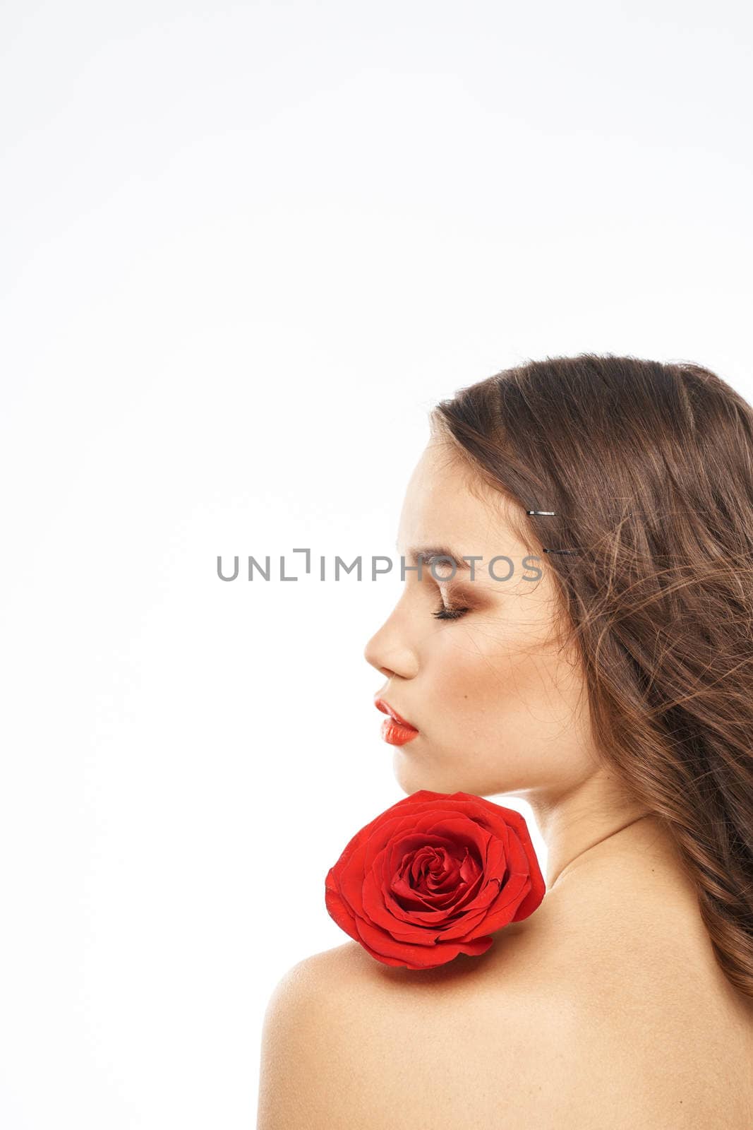 Portrait of woman with red rose naked shoulders Make-up on brunette face. High quality photo