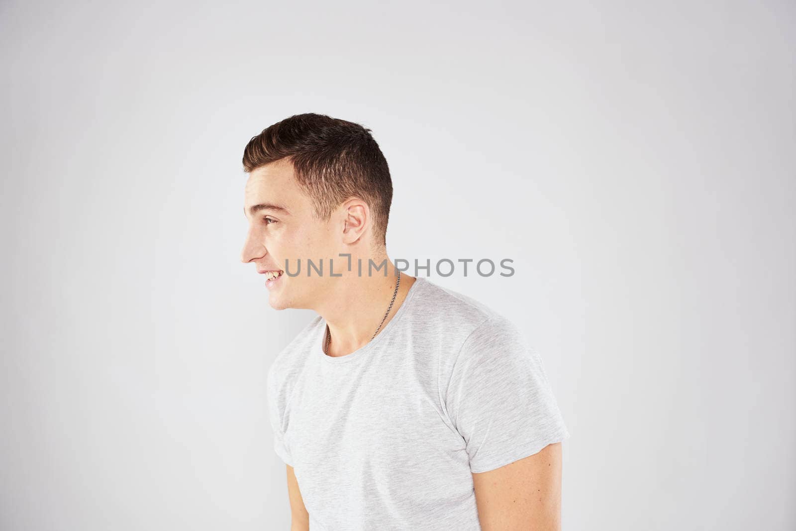 Man in a white t-shirt emotions gestures with hands close-up cropped view light background by SHOTPRIME
