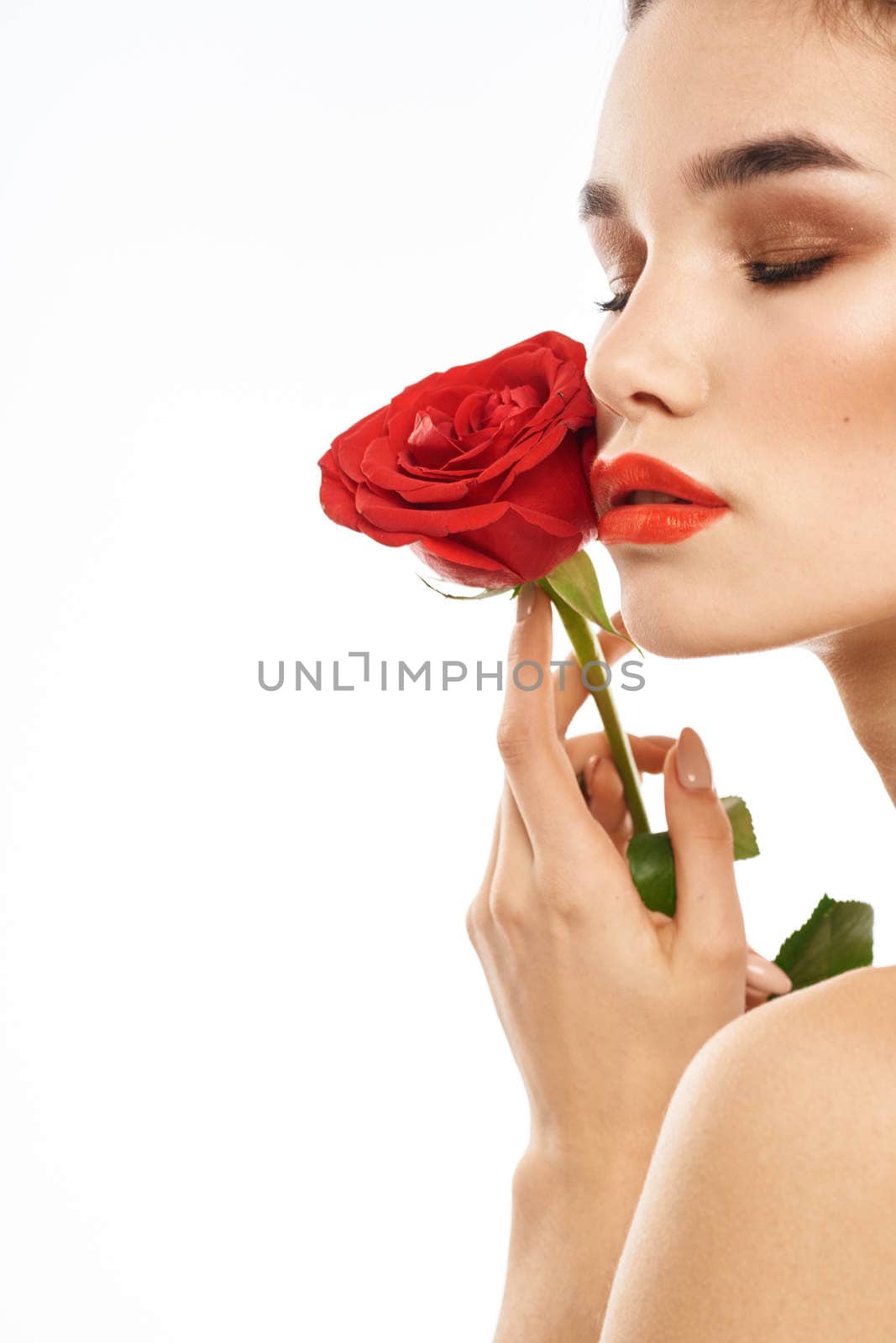 Portrait of woman with red rose naked shoulders Make-up on brunette face. High quality photo