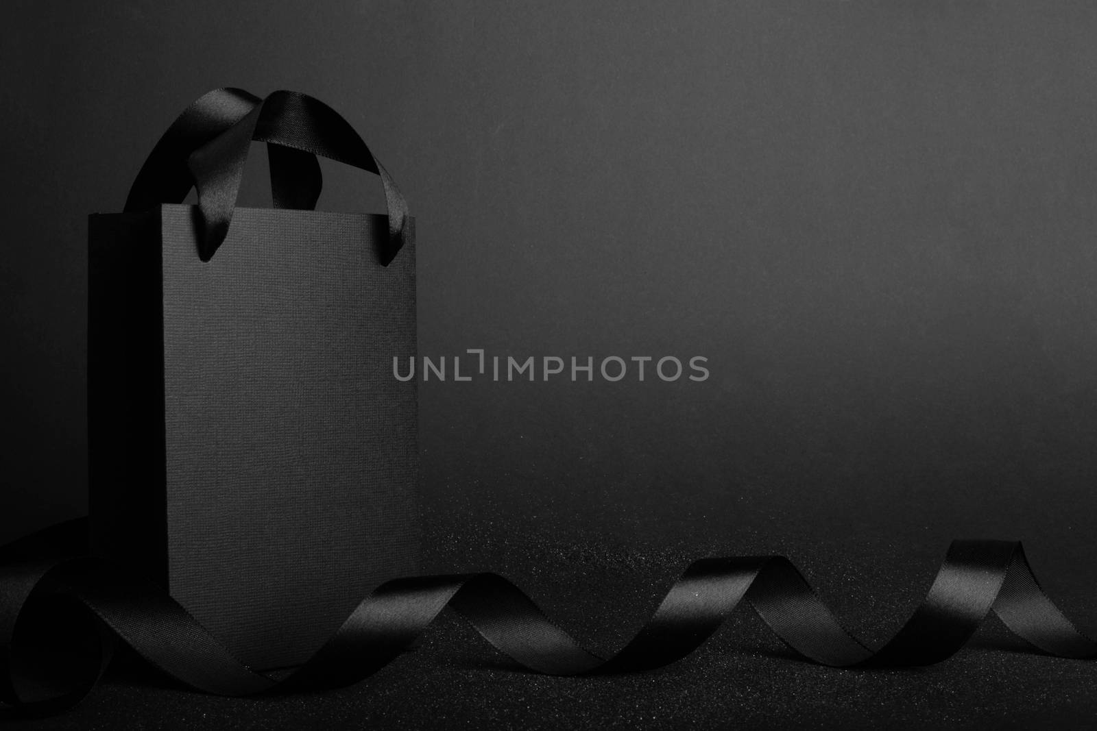 Black Friday blank empty paper bag with copy space for text and logo on dark background sale concept banner backgrounds