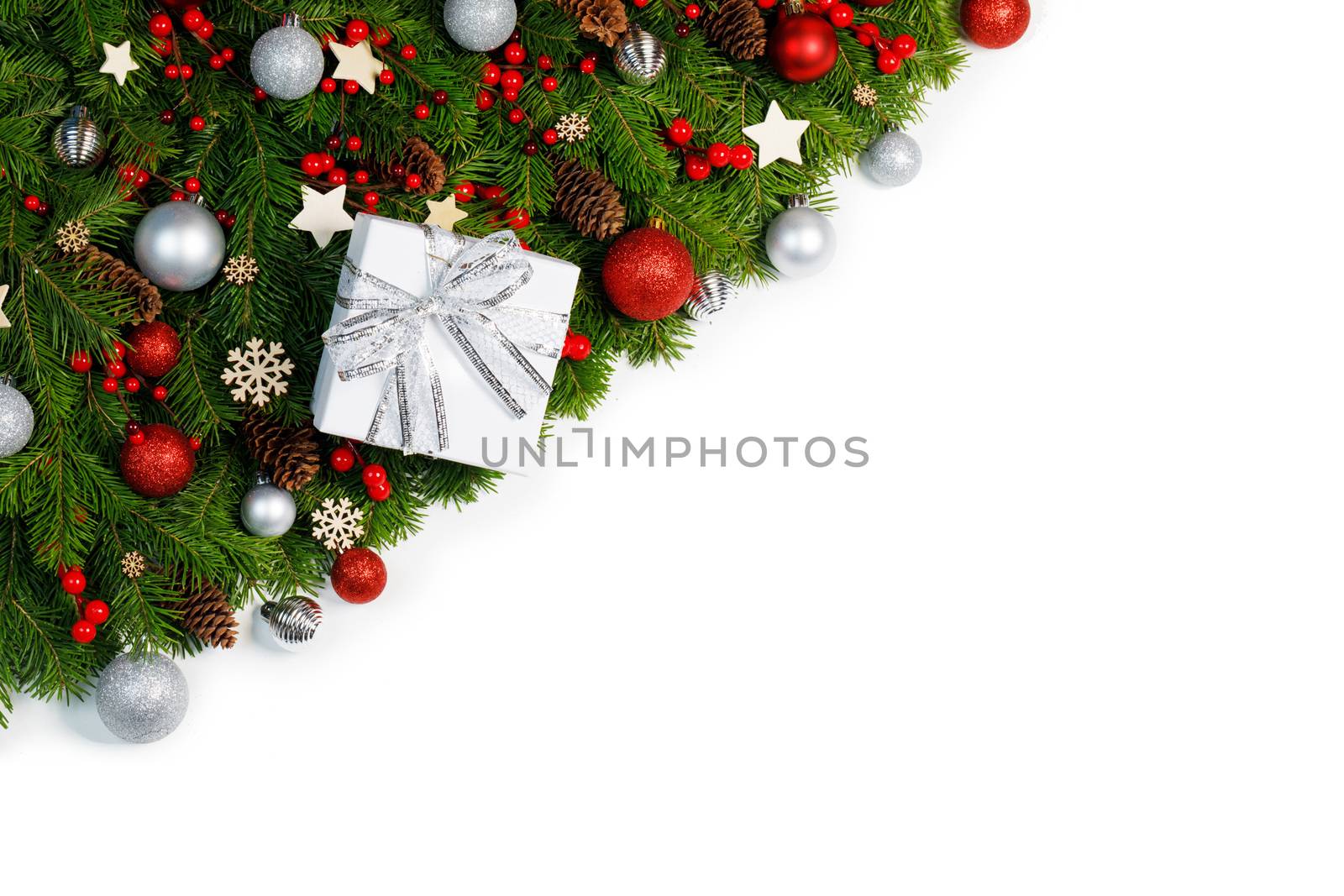 Christmas corner Border frame of tree branches isolated on white background with copy space , red and silver decor, berries, stars, cones, gift box