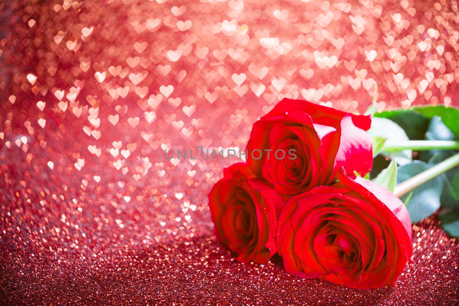 Three red roses and over hearts bokeh glittering background