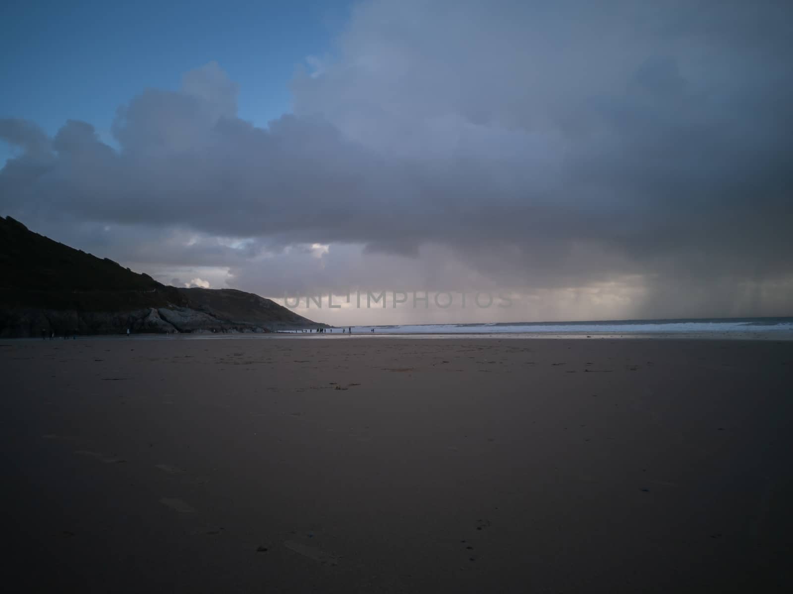 Stormy Skies with torrential downpour out at sea at Caswell Bay in Gower, Wales, UK. Rain on the beach in late Autumn.
