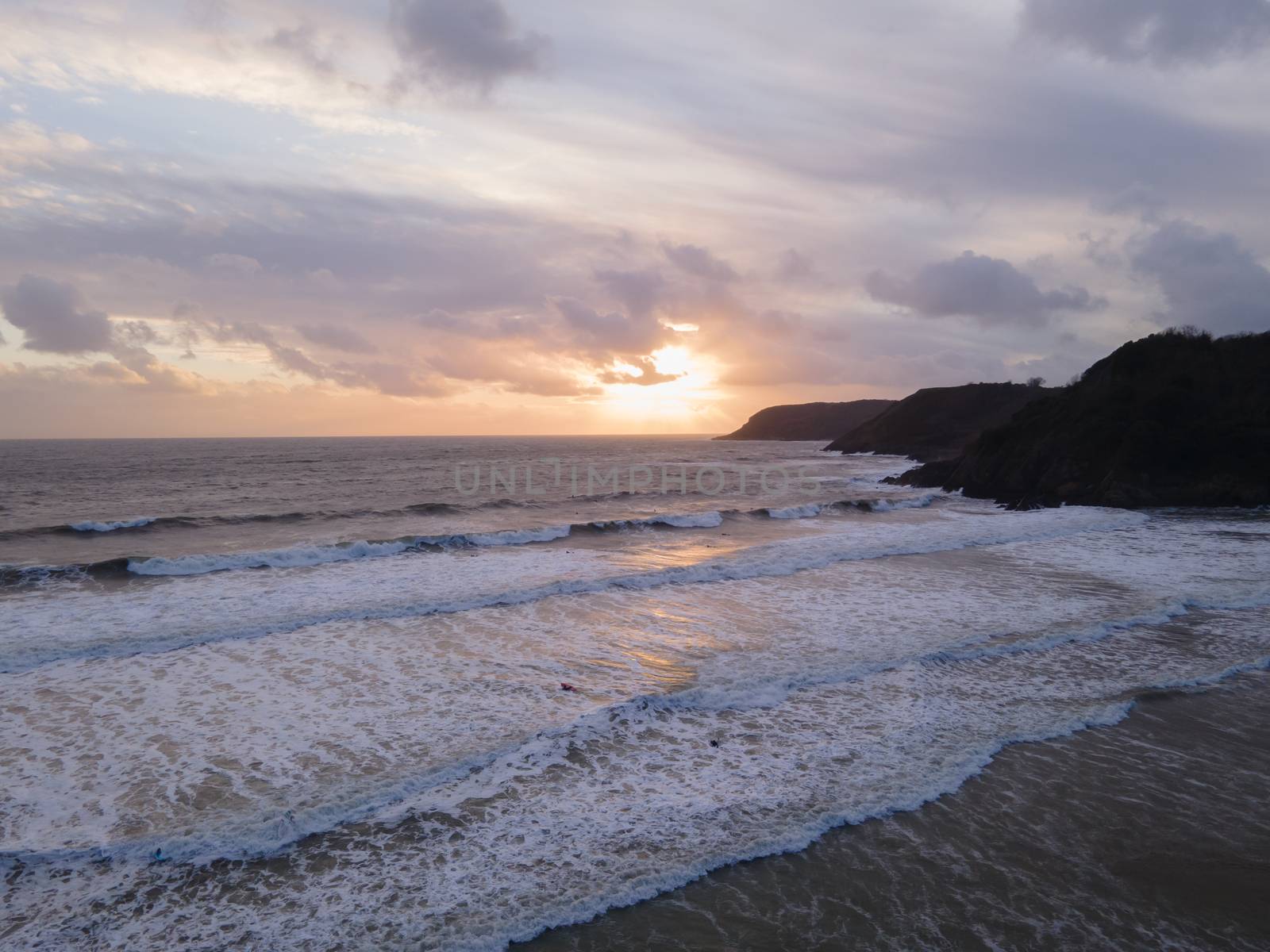 A Stunning Coastal Sunset Full Of Colour Overlooking the Sea At Caswell Bay in Gower, Wales UK
