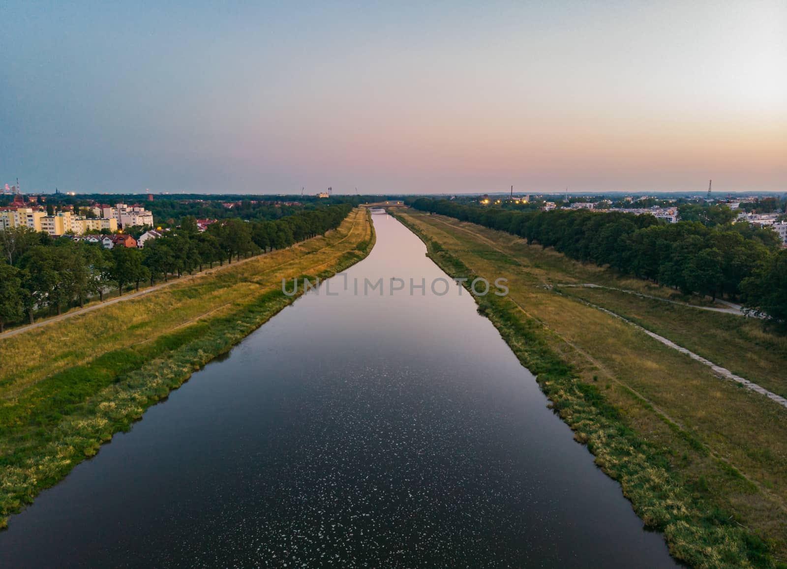 Aerial look to long river with waves between trees at sunny morning by Wierzchu