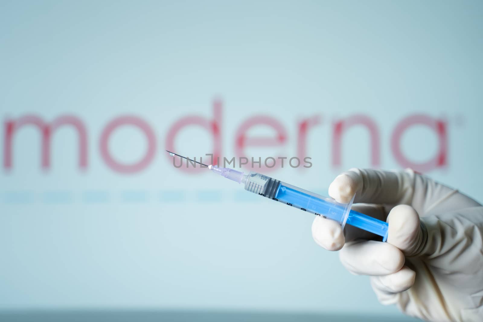 Maski, India 17, November 2020 : Illustrative editorial of Doctor holding covid-19 coronavirus moderna injection vaccine syringe on Moderna background.