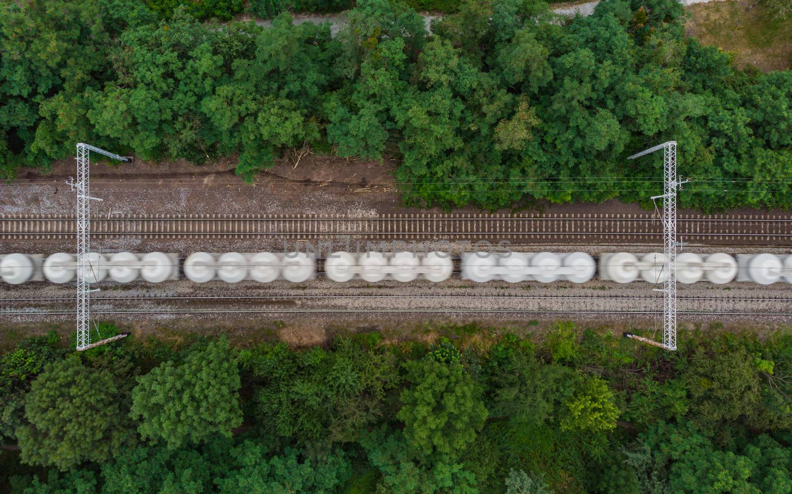 Top down aerial look to driving goods train between trees